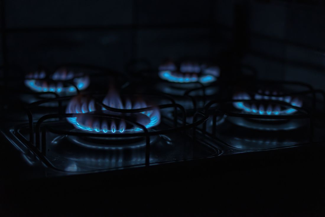 The blue flames of a lit gas hob