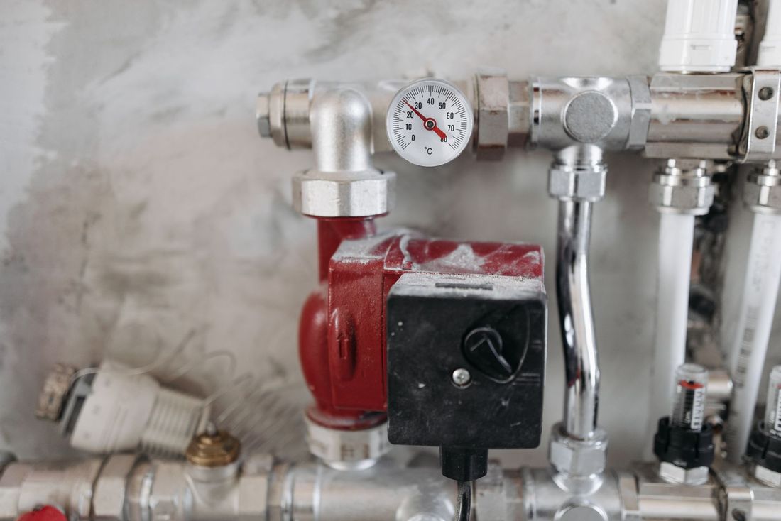 A pressure gauge and pump on a domestic heating manifold